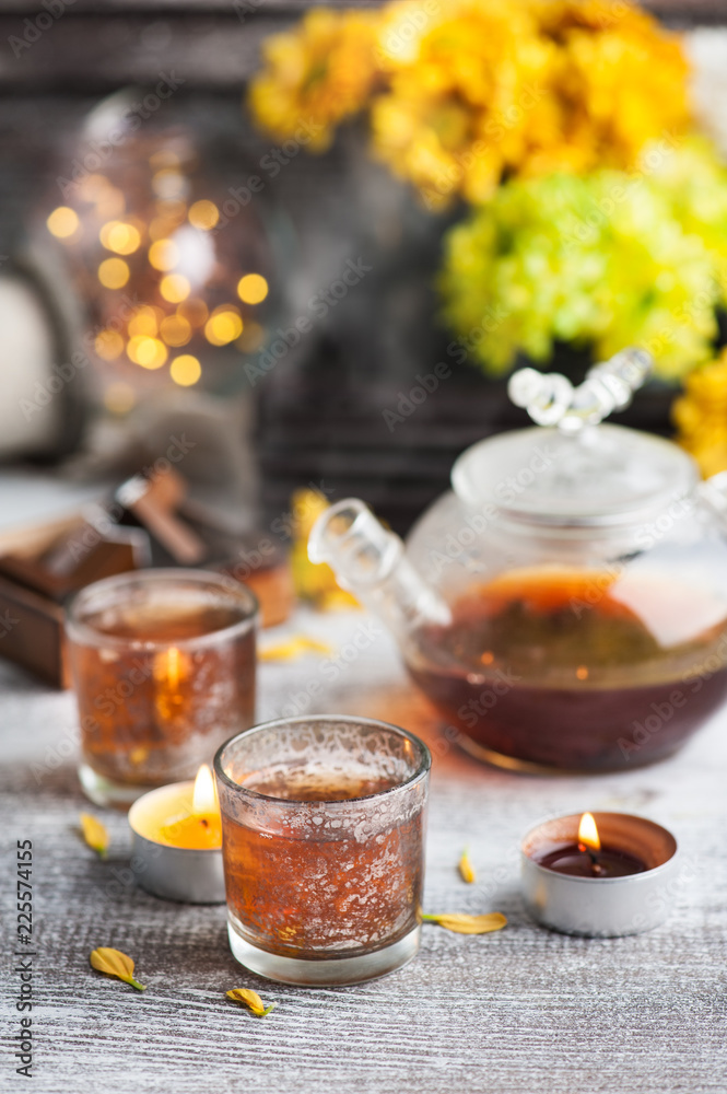 Glasses with lit candles and tea pot