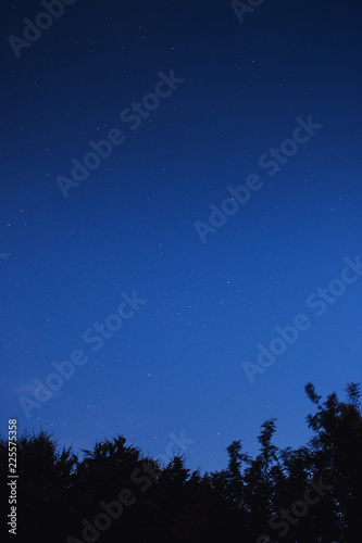 Big Dipper star constellation on a cloudy colorful sunset night sky view with blue and red tones palette.