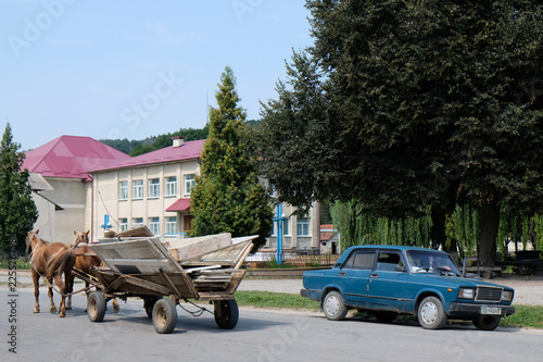 Ukraina - wóz konny i stary samochód na ulicy w mieście photo