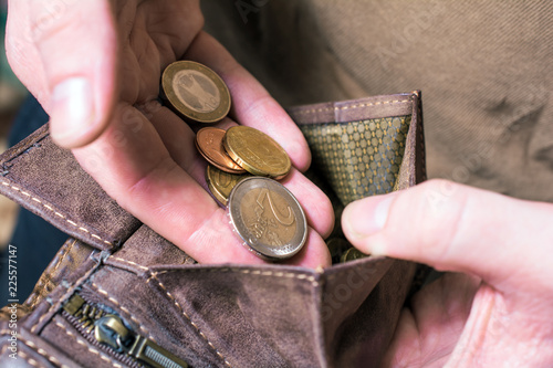 Man Putting Some Euro Coins In His Wallet photo