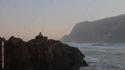 Fisherman along the rocks in the Knysna heads fishing for sport and relaxation n the rough water at the entrance to the lagoon. In the? Garden route, western cape region of South Africa photo