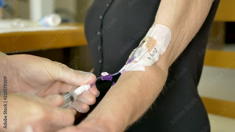 Vidéo Stock Medical nurse doing an at home iv patient visit wearing sterile gloves and injecting