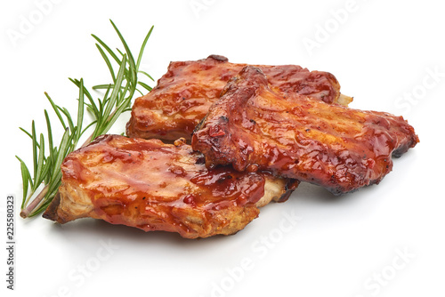 Delicious grilled pork ribs in BBQ sauce with herbs, isolated on white background. Close-up.
