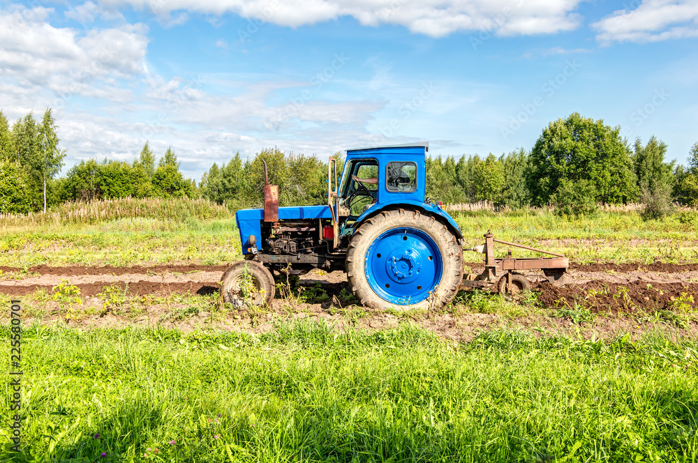 Fototapeta premium Agricultural tractor working at the potato field