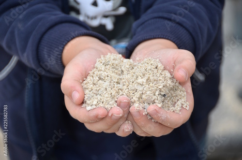 Kleinkind hält Sand in den Händen