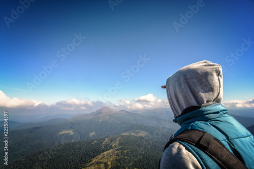 Man traveler on the top of Mount Petros looks at Mount Hoverla in the Ukrainian Carpathians