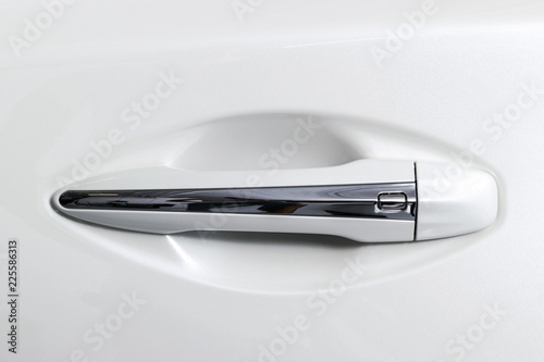 The modern door handle of a white car. Car detailing. Car exterior details. Closeup Car door handle. Car equipment concept.