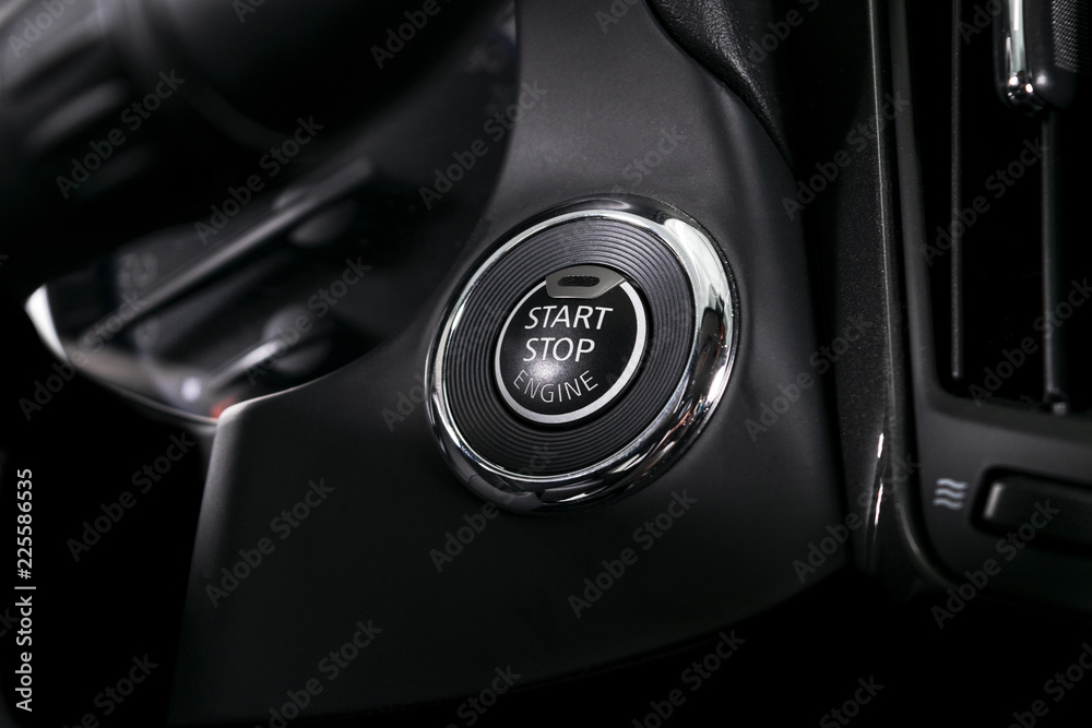 Car dashboard with focus on engine start stop button. Modern car interior details. Car detailing