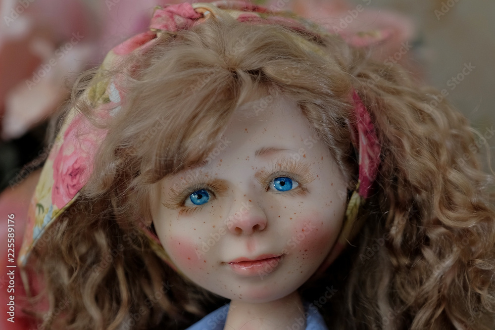 Face ceramic doll with blue eyes and freckles closeup. Face ceramic doll with blue eyes and freckles closeup.