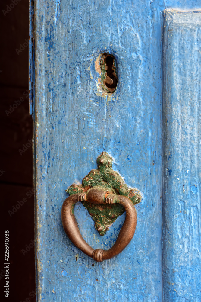 Old and aged blue historic church wooden door in the city of Sabara, Minas Gerais with its rusty metal part.