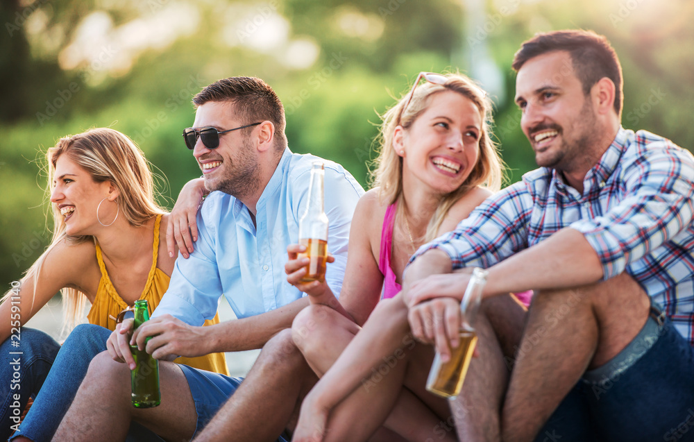 Group of friends enjoying picnic on the beach. Lifestyle, vacation, relationships concept Group of friends enjoying picnic on the beach. Lifestyle, vacation, relationships concept