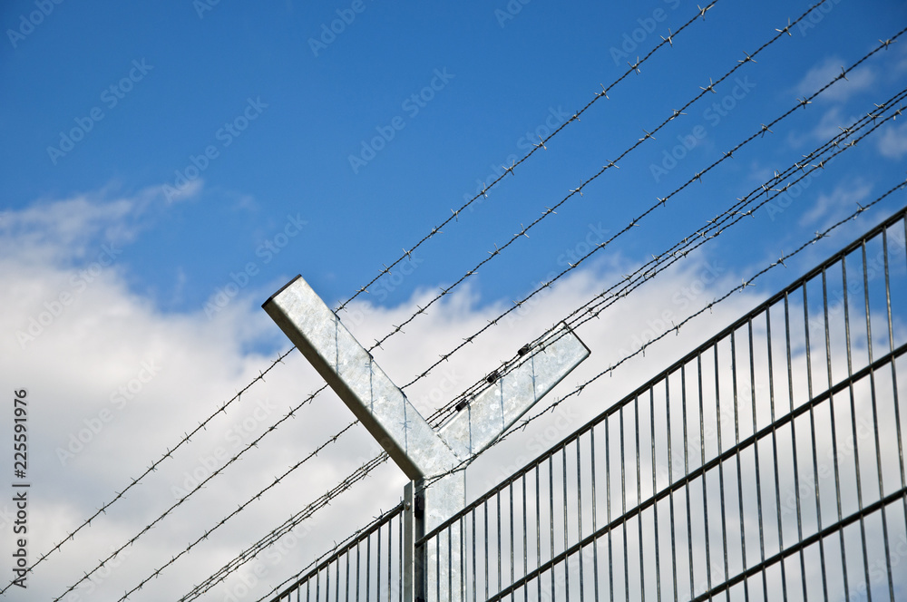 Fence with barbwire with blue sky Fence with barbwire with blue sky