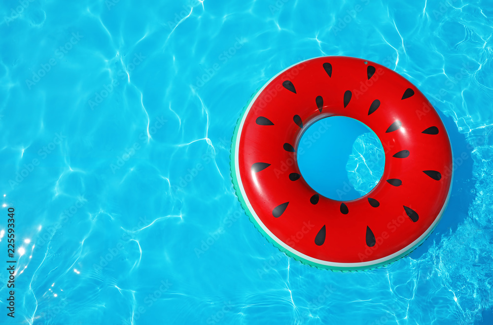Obraz premium Inflatable ring floating in swimming pool on sunny day, top view with space for text