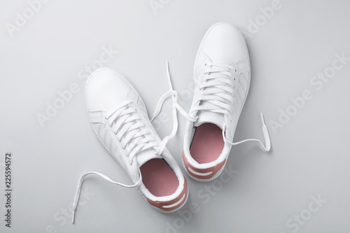 Pair of trendy sneakers on light background, flat lay
