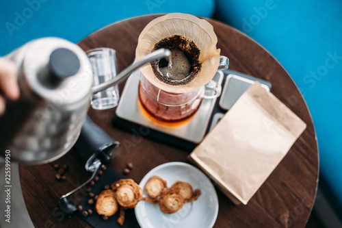 Hand drip coffee, barista pouring water on coffee ground with filter