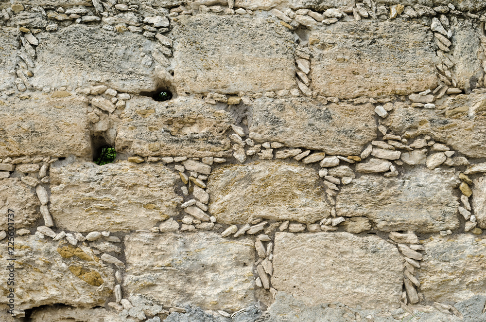 Stone wall, small stones forming square bricks. Stone wall, small stones forming square bricks.