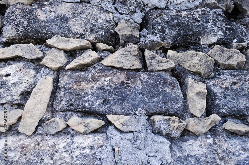 Fototapeta premium Stone wall, small stones forming square bricks.