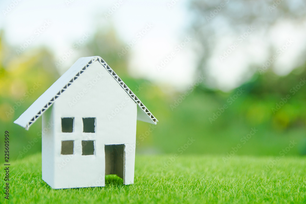 Eco house concept : Cardboard cut house on green grass with copy space Eco house concept : Cardboard cut house on green grass with copy space