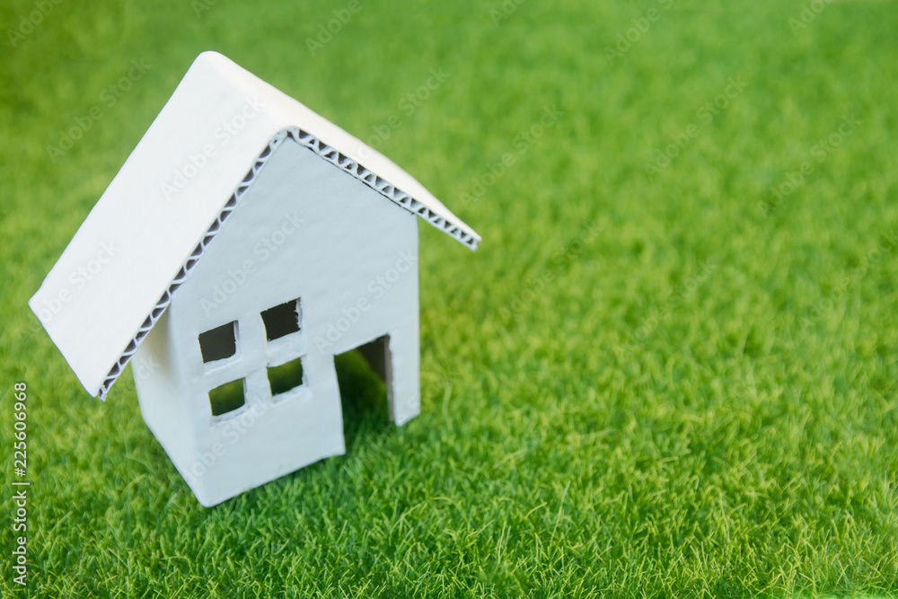 Eco house concept : Cardboard cut house on green grass with copy space Eco house concept : Cardboard cut house on green grass with copy space