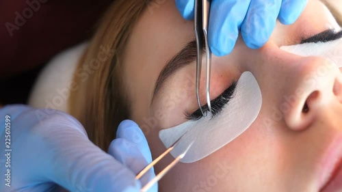 Artificial eyelash extensions from the master of eyelash extension in the beauty salon, medical tweezers hd