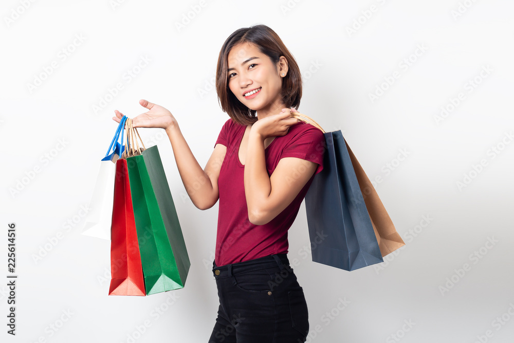 Beautiful asian young woman smiling holding shopping bags isolated on white background.