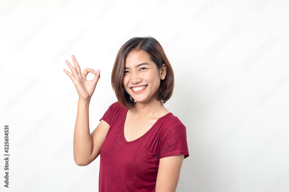 Beautiful asian woman smiling with hand ok sign on a white isolated background Beautiful asian woman smiling with hand ok sign on a white isolated background