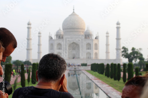 Photography The tourists taking photos of Taj Mahal in a crowd.