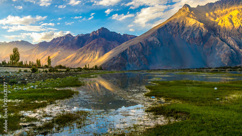 Very scenic and beautiful view of Nubra Valley mountians and reflection in water sunset in Ladakh photo