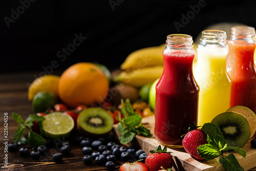 Fresh and Healthy Juices Fruits. Various freshly squeezed fruits and vegetables juices on the old wooden and back background. Healthy and Diet Concept