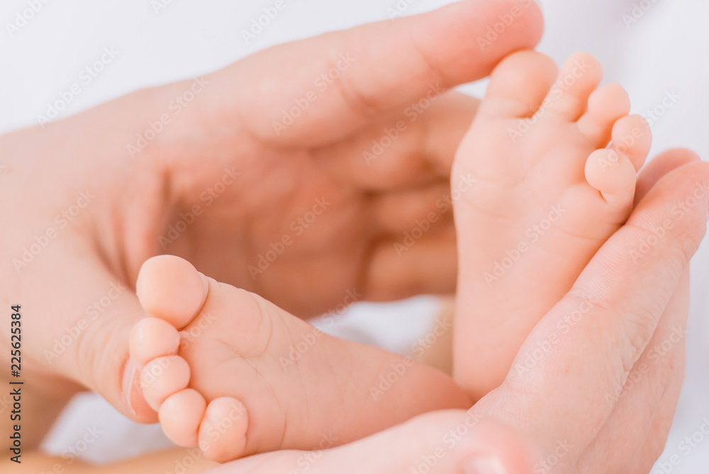 Close-up of mother hands holding tiny baby feet Close-up of mother hands holding tiny baby feet