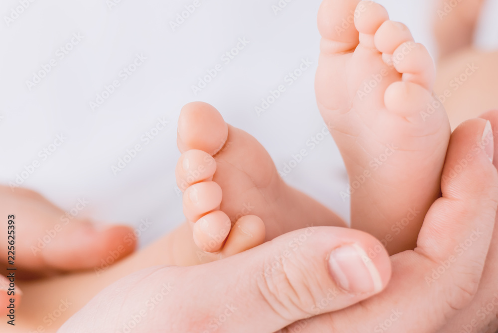 Close-up of mother hands holding tiny baby feet Close-up of mother hands holding tiny baby feet
