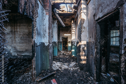 Creepy corridor of burnt abandoned building. Ruined ceiling and roof