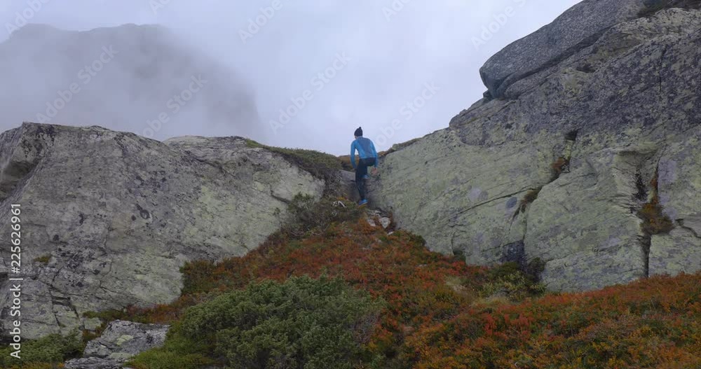 Young man walks in the mountains on a nice autumn day. Smooth panning shot.