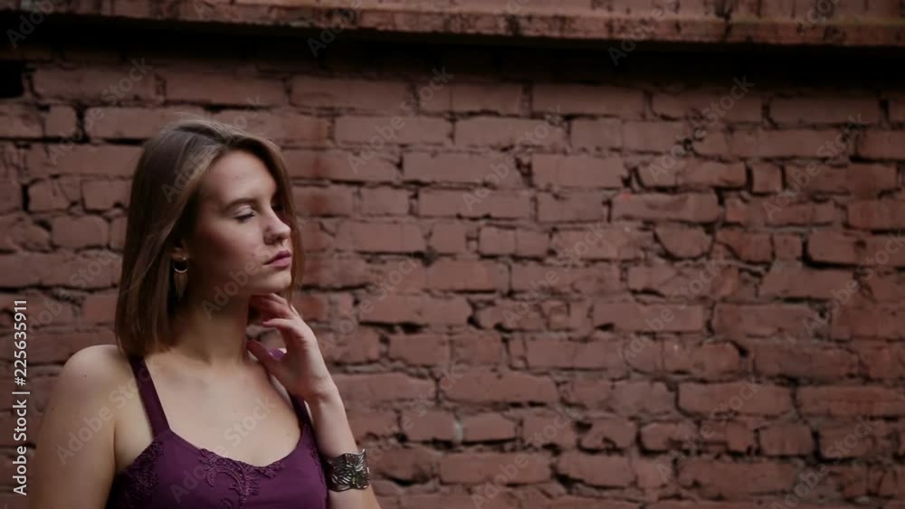 Portrait of happy young woman shaking her beautiful curly hair on brick wall. Portrait of happy young woman shaking her beautiful curly hair on brick wall.
