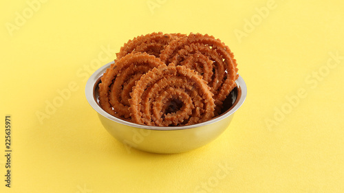 Chakli or chakkuli is a traditional, popular, vegetarian and delicious Indian savory snack, typically made during some festivals, in a steel bowl. photo