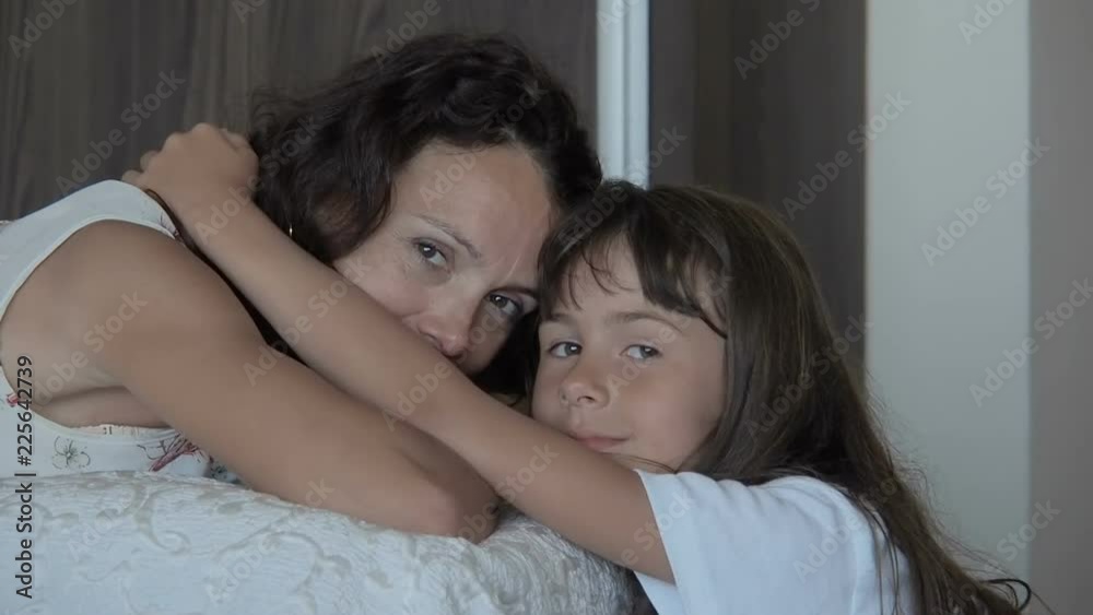 Portrait of a mother with a daughter. The child hugs the mother. Portrait of a mother with a daughter. The child hugs the mother.
