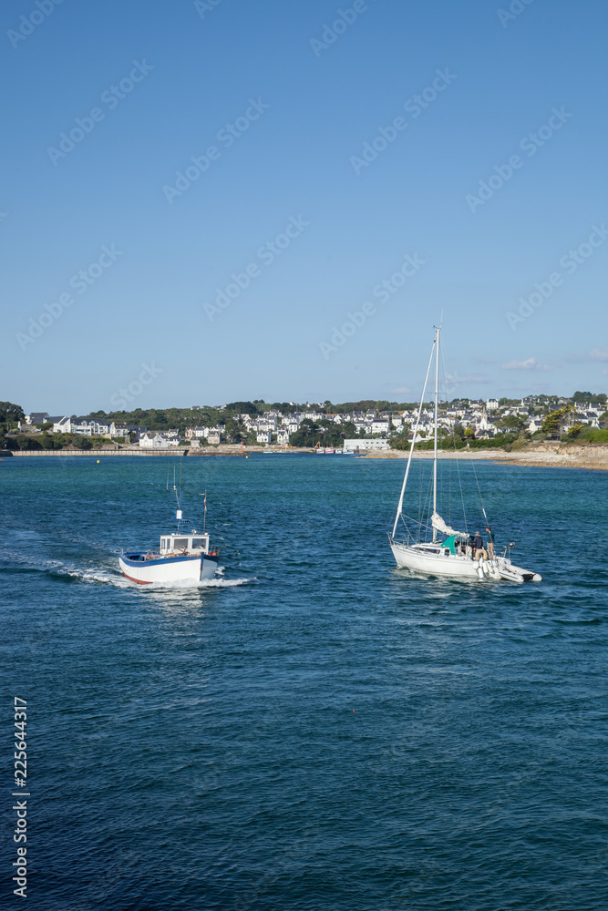 Petit bateau de pêche et bateau de plaisance se croisant dans la baie d'Audierne (Finistère)