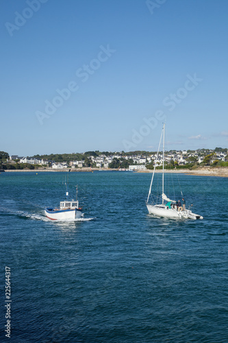 Petit bateau de pêche et bateau de plaisance se croisant dans la baie d'Audierne (Finistère)
