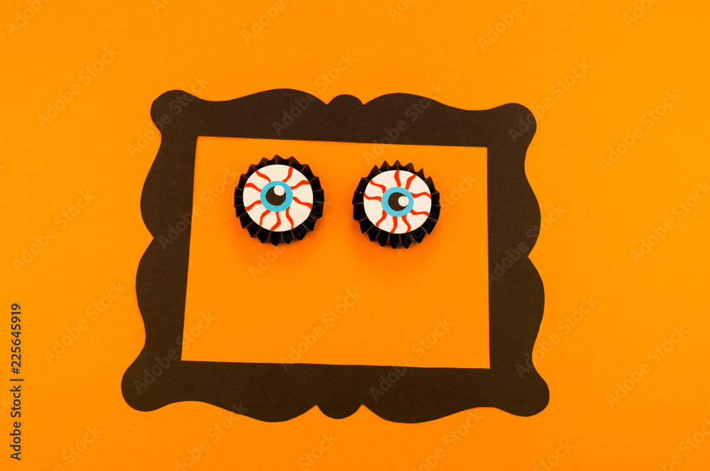 Eyes pumpkin monster from paper orange background