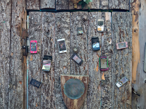 eleven cell phones nailed to the front door of a wooden house