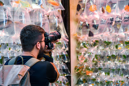 Man taking a photo at goldfish market in Hong Kong