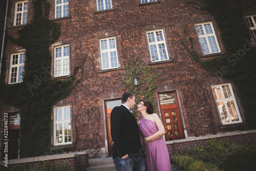 Young wedding couple in love story, bride and groom posing near building on the background. Krakow