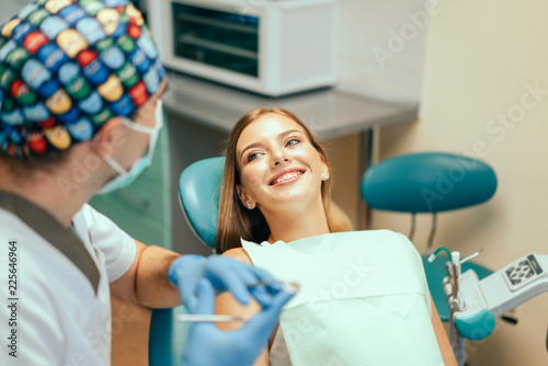 Dentist examine female patient with braces in denal office.