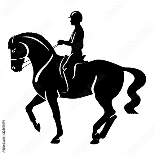 A silhouette of a rider on a horse execute the piaffe.