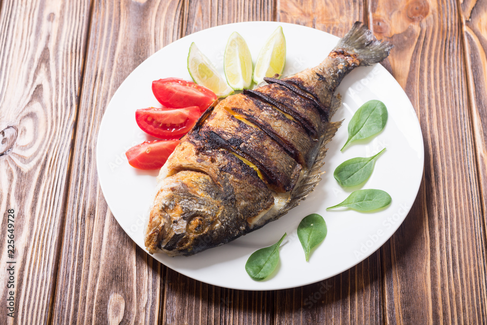 Fried fish dorado with lime , tomatoes and spinach Fried fish dorado with lime , tomatoes and spinach