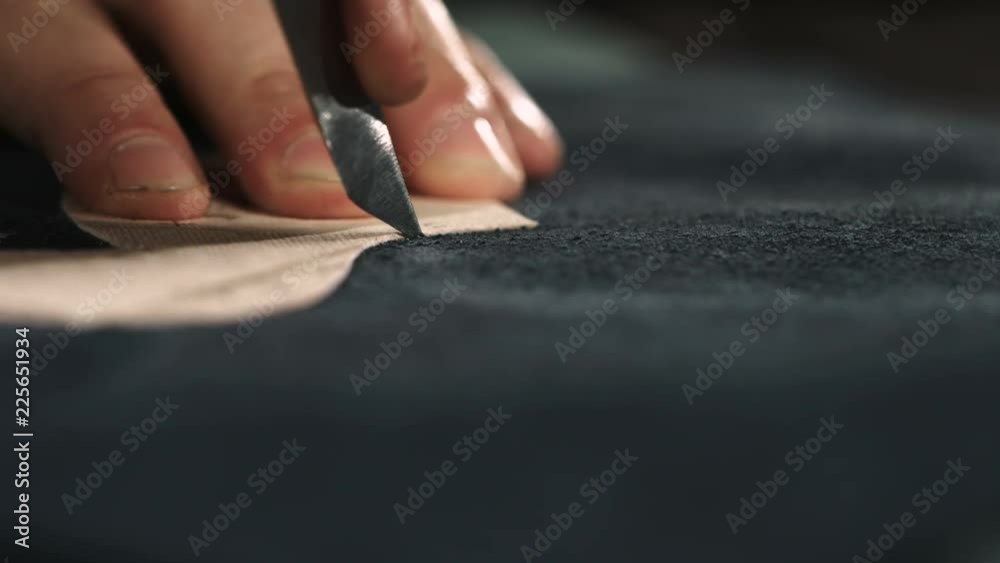 The master makes shoes in the workshop. Cutting shoe leather as template, clicking the upper. Indoor. 4K 60fps