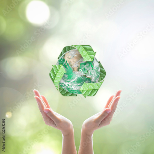 World environment day and ecology concept with woman human hands under green planet with recycle sign. Elements of this image furnished by NASA photo