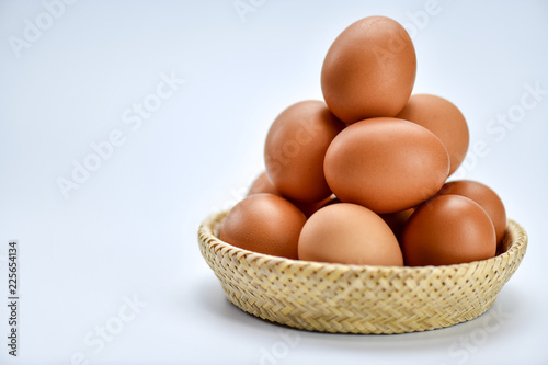 Brown eggs in the basket on a white background.
