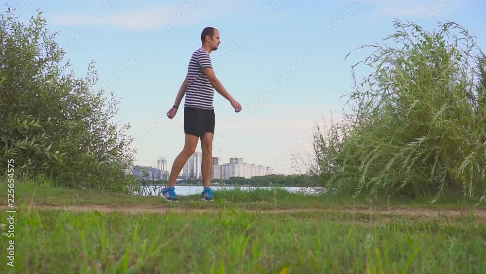 Young man in shorts rejoices at success in cityscape Young man in shorts rejoices at success in cityscape