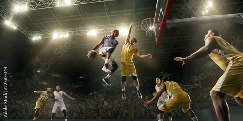 Basketball players on big professional arena during the game. Basketball player makes slum dunk © Alex